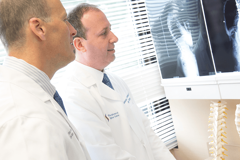 dr. jason lowenstein & dr. george naseef examining spine x-ray