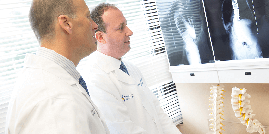 dr. jason lowenstein & dr. george naseef examining spine x-ray