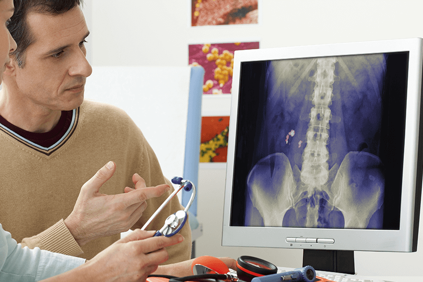 spine doctor and patient reviewing x-ray for back pain emergency