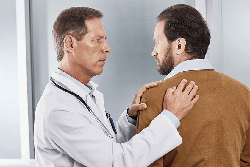 doctor examining patient with upper back pain