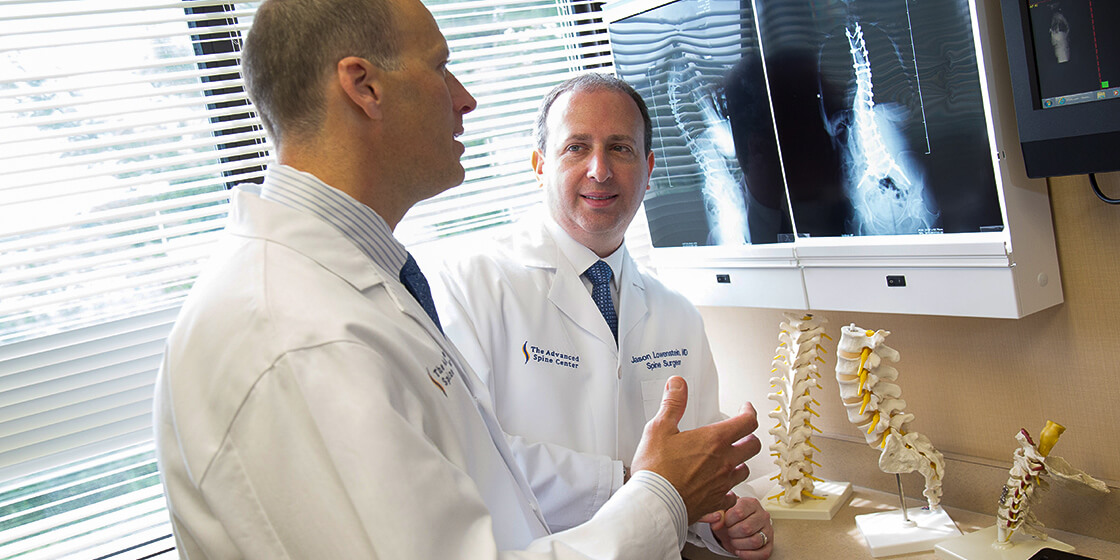 dr. lowenstein examines scoliosis x-ray