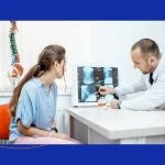Spine surgeon reviewing recurrent lumbar disc herniation treatment options with a patient.